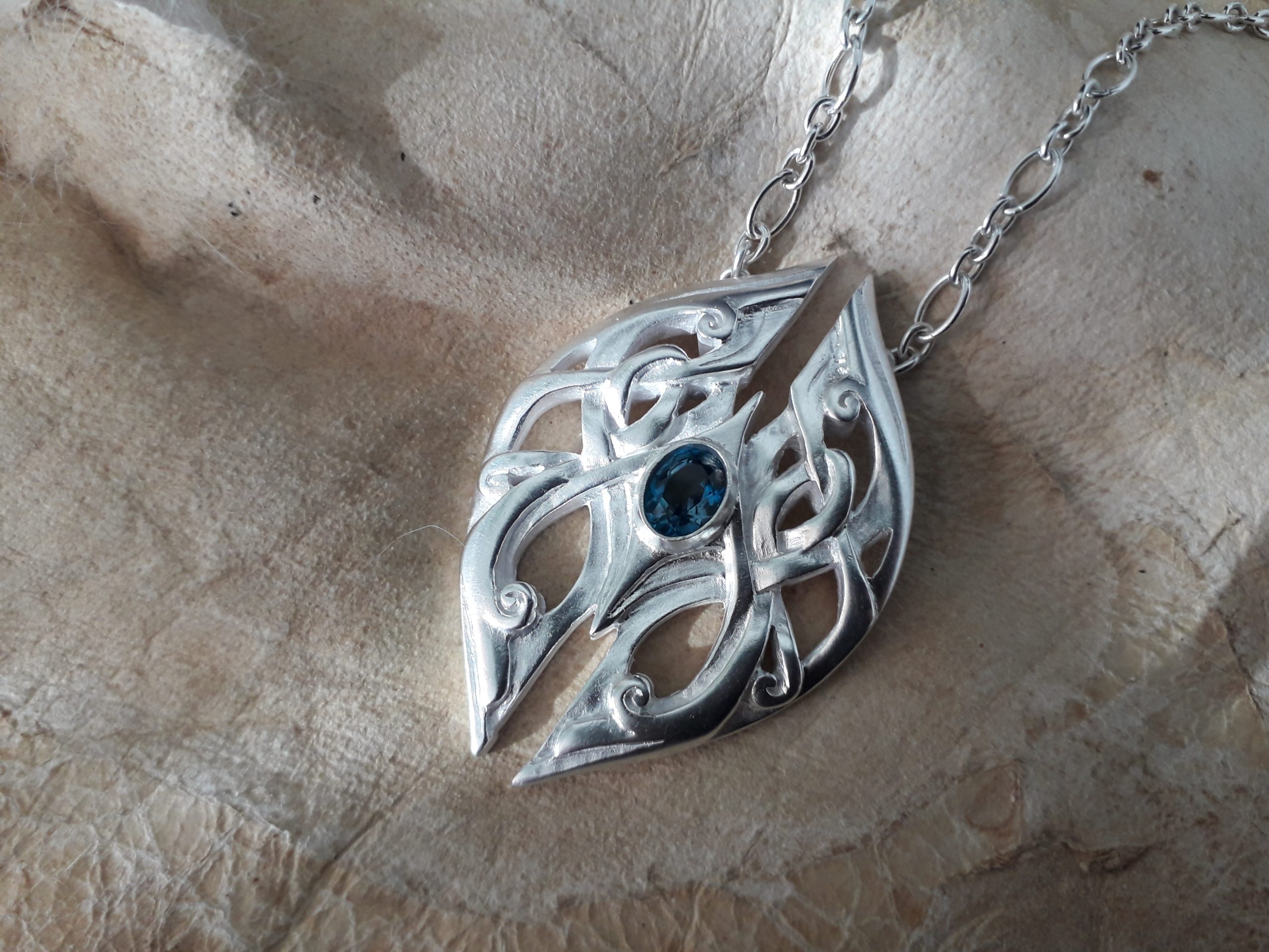 Geminae Danicae Amulet in silver with silver chains. Set with a mesmerizing London blue Topaz.